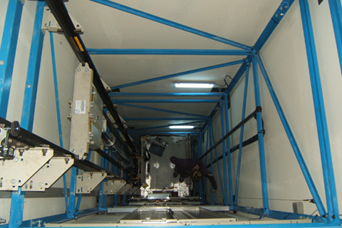 A Stannah engineer within a steel frame supported passenger lift